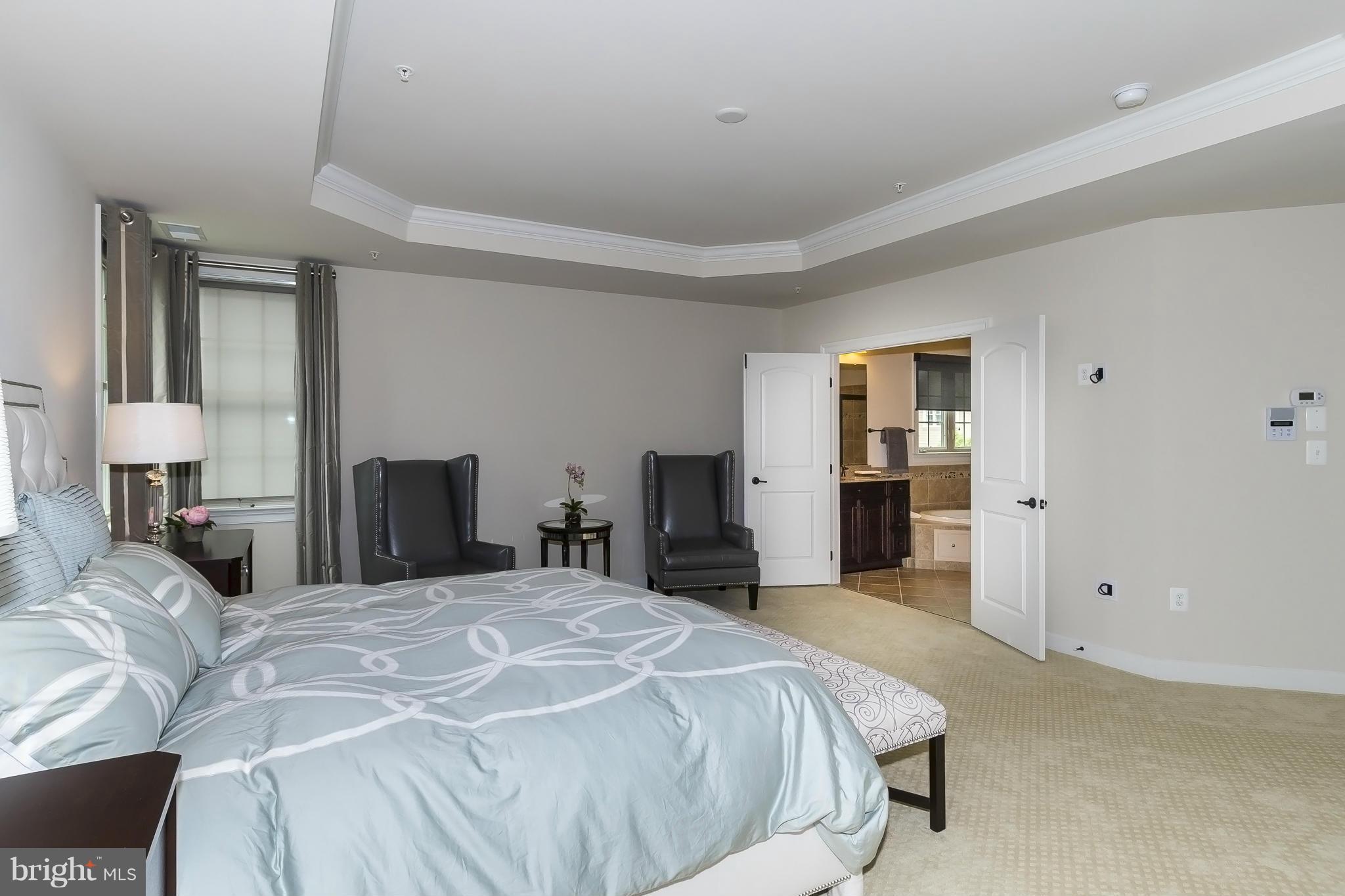 7733 Elmwood Road Fulton, MD 20759 - Photo 15 of 30 a bedroom with a large bed and a chandelier