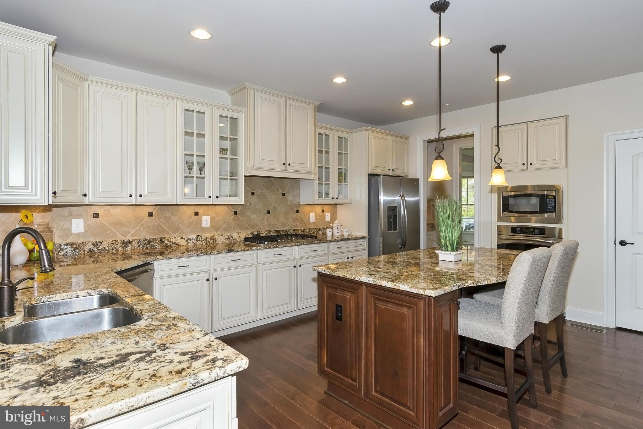 7733 Elmwood Road Fulton, MD 20759 - Photo 8 of 30 a kitchen with stainless steel appliances granite countertop a table chairs sink refrigerator and cabinets