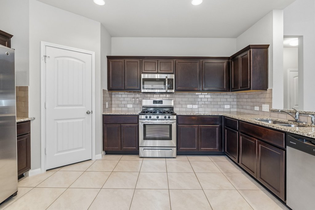 6517 Ranchito Drive Austin, TX 78744 - Photo 12 of 36 Functional kitchen with ample cabinetry, pantry space, and workspace