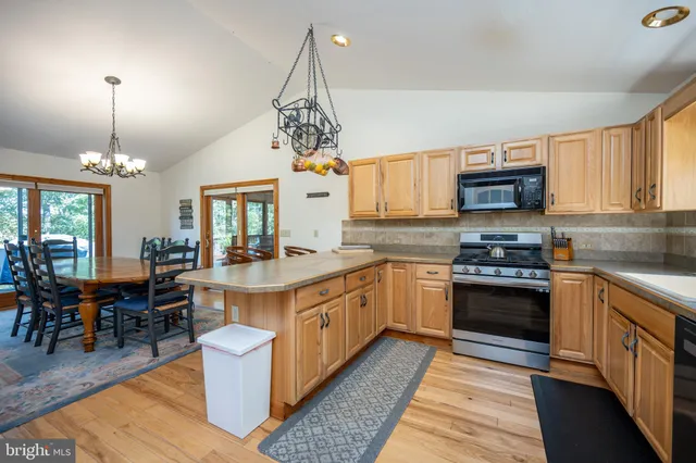 a kitchen with stainless steel appliances granite countertop a sink refrigerator stove and microwave