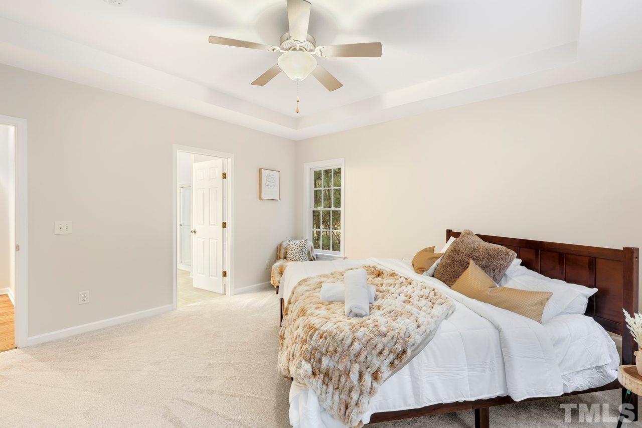 7015 Cedar Road Sanford, NC 27332 - Photo 12 of 30 a bedroom with a bed and a chandelier