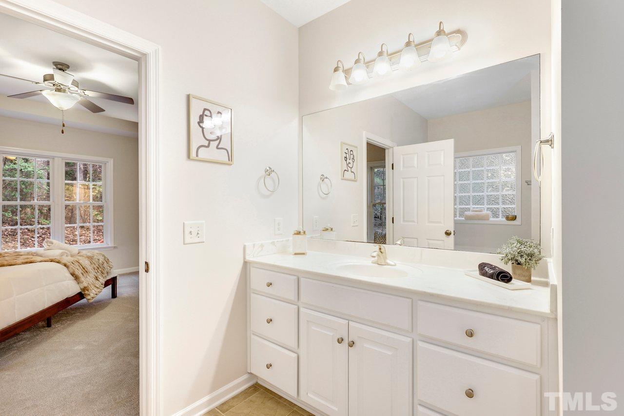 7015 Cedar Road Sanford, NC 27332 - Photo 15 of 30 a en suite bathroom with a double vanity sink a mirror and a shower