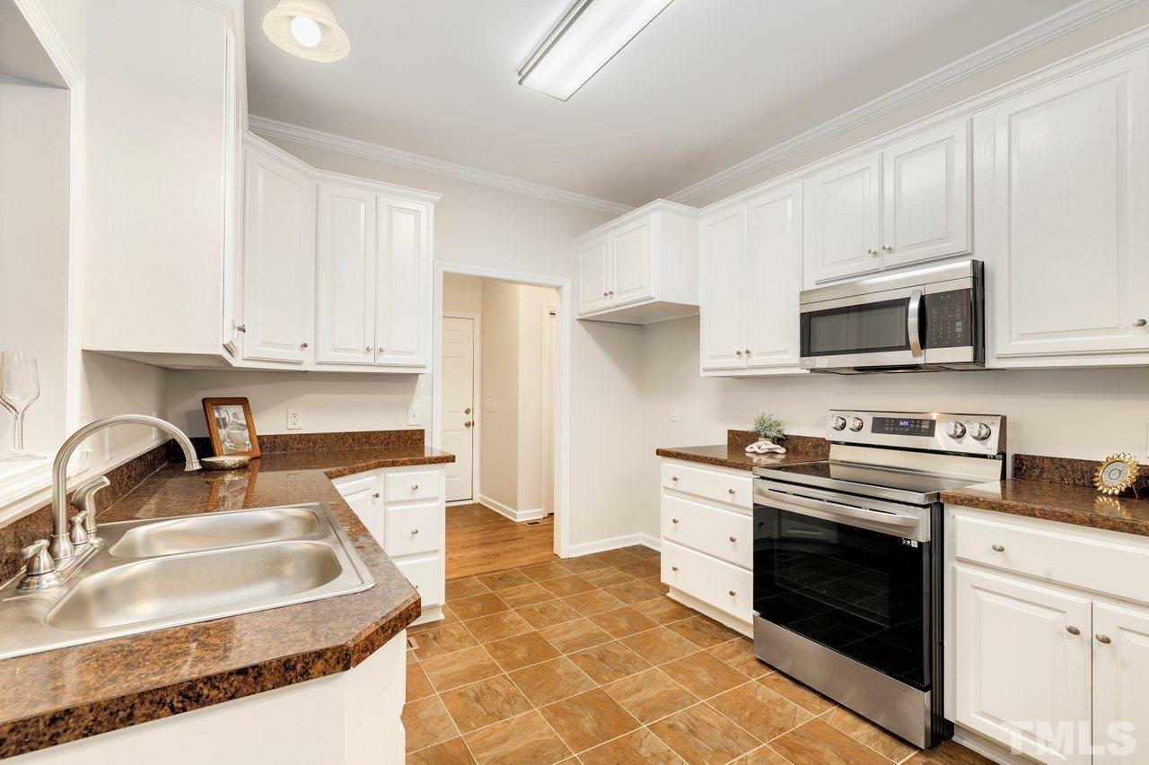 7015 Cedar Road Sanford, NC 27332 - Photo 5 of 30 a kitchen with stainless steel appliances granite countertop a sink stove oven a refrigerator with white cabinets and granite countertops
