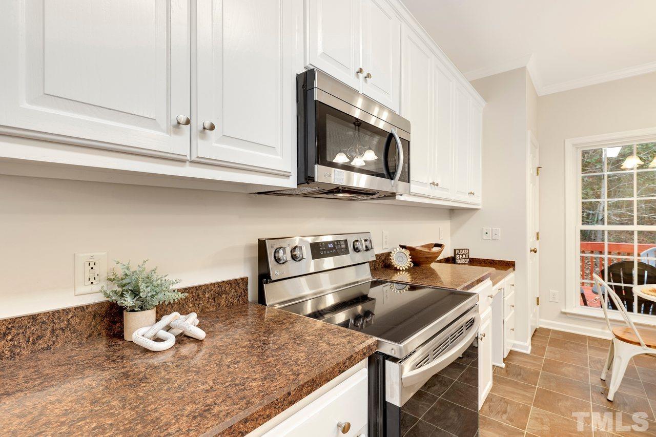 7015 Cedar Road Sanford, NC 27332 - Photo 7 of 30 a kitchen with granite countertop a stove a microwave a sink and cabinets