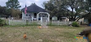 496 Romona Road Seadrift, TX 77983 - Photo 2 of 35 a view of a house with a small yard and a large tree