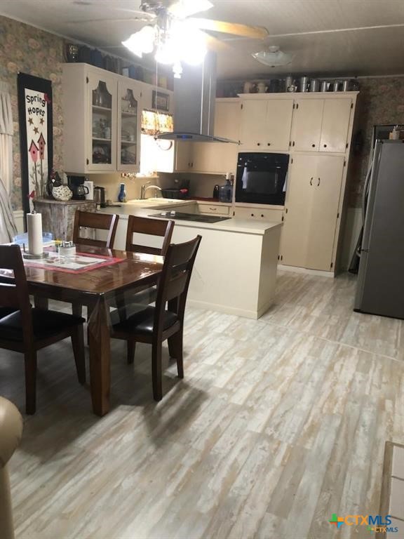 496 Romona Road Seadrift, TX 77983 - Photo 4 of 35 a kitchen with stainless steel appliances a dining table chairs and granite counter tops