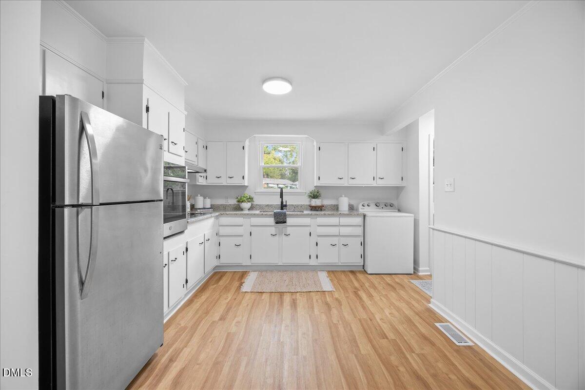 3437 Apache Drive Raleigh, NC 27609 - Photo 14 of 33 a kitchen with stainless steel appliances a refrigerator sink and cabinets