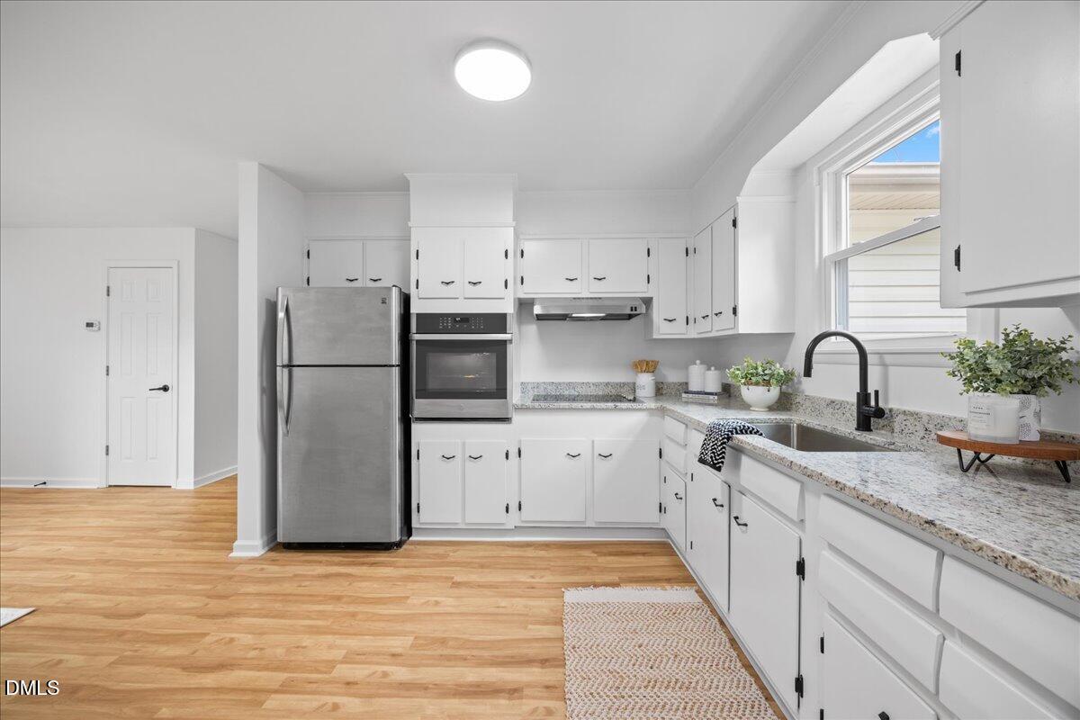 3437 Apache Drive Raleigh, NC 27609 - Photo 15 of 33 a kitchen with white cabinets and stainless steel appliances