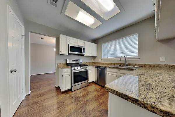 a kitchen with a sink stove top oven and refrigerator