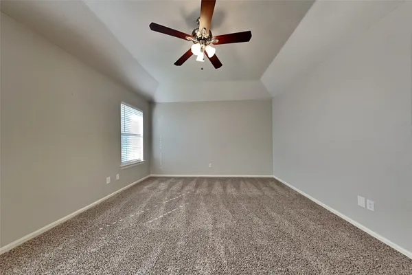an empty room with windows and fan