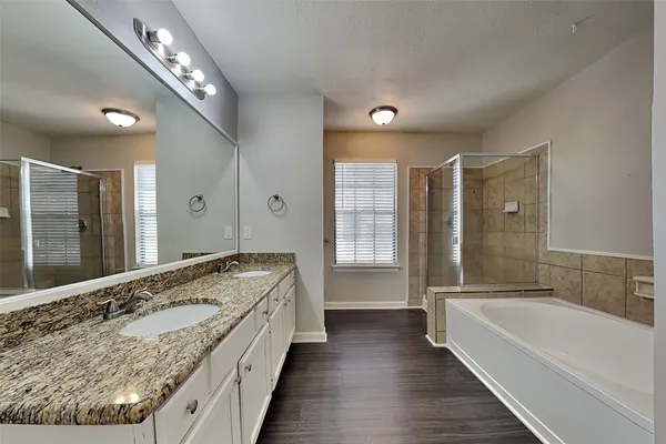a spacious bathroom with a tub shower and windows