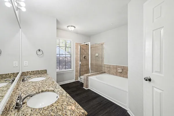 a bathroom with a tub sink and mirror