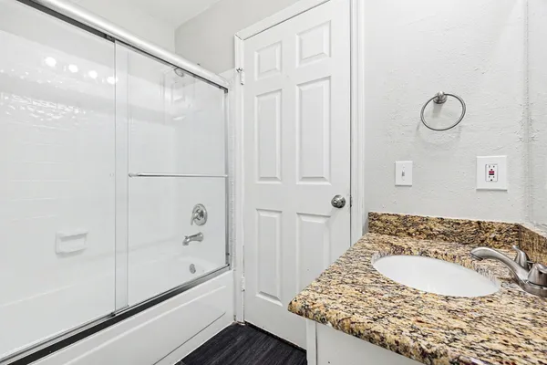 a bathroom with a granite countertop sink and a mirror
