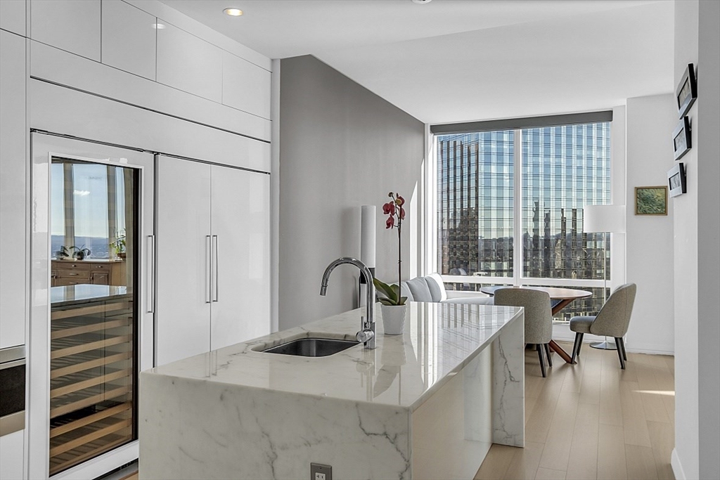 1 Franklin Street, Unit 4606 Boston, MA 02110 - Photo 12 of 38 a kitchen with kitchen island a sink table and chairs