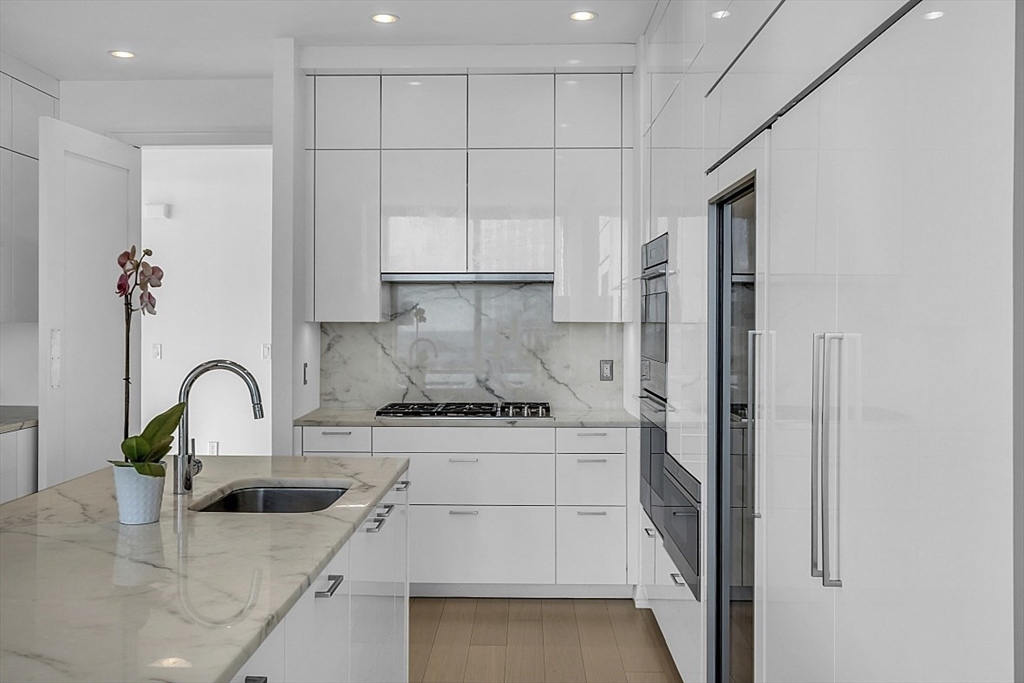 1 Franklin Street, Unit 4606 Boston, MA 02110 - Photo 14 of 38 a kitchen with stainless steel appliances granite countertop a sink a stove and a refrigerator