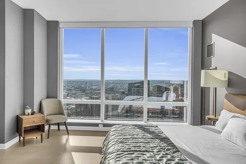 a bedroom with a bed and a large window