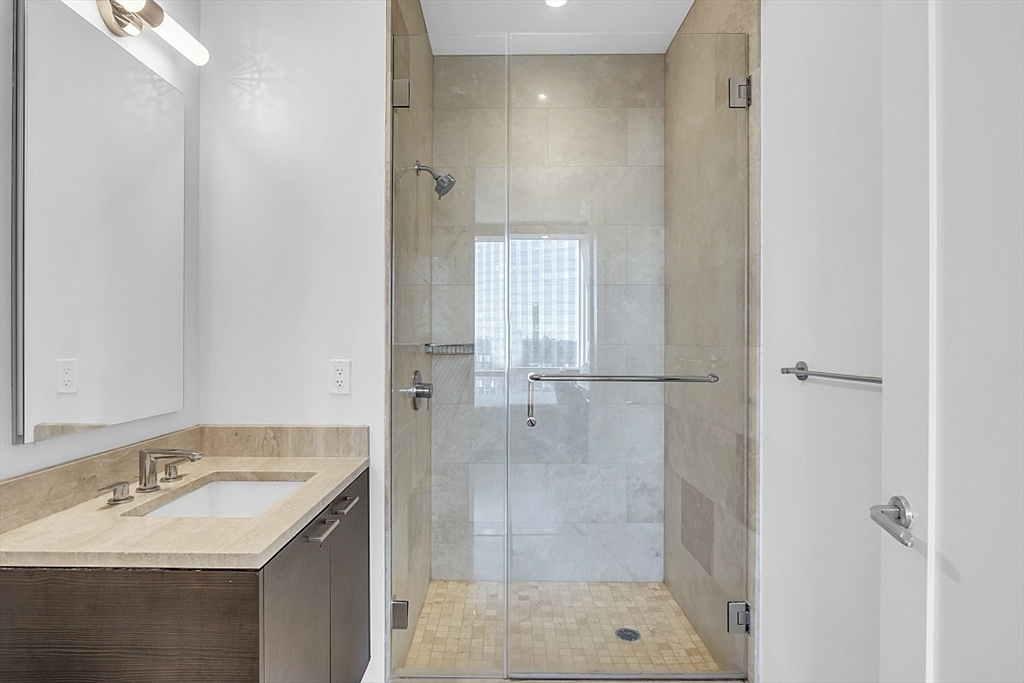 1 Franklin Street, Unit 4606 Boston, MA 02110 - Photo 22 of 38 a bathroom with a shower sink and mirror