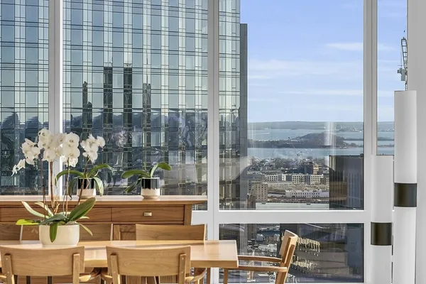 a dining room with furniture water view and large windows