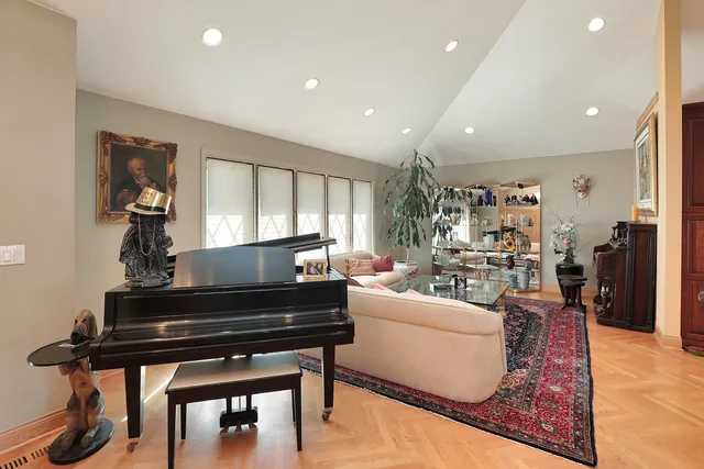 a living room with furniture a piano and a potted plant