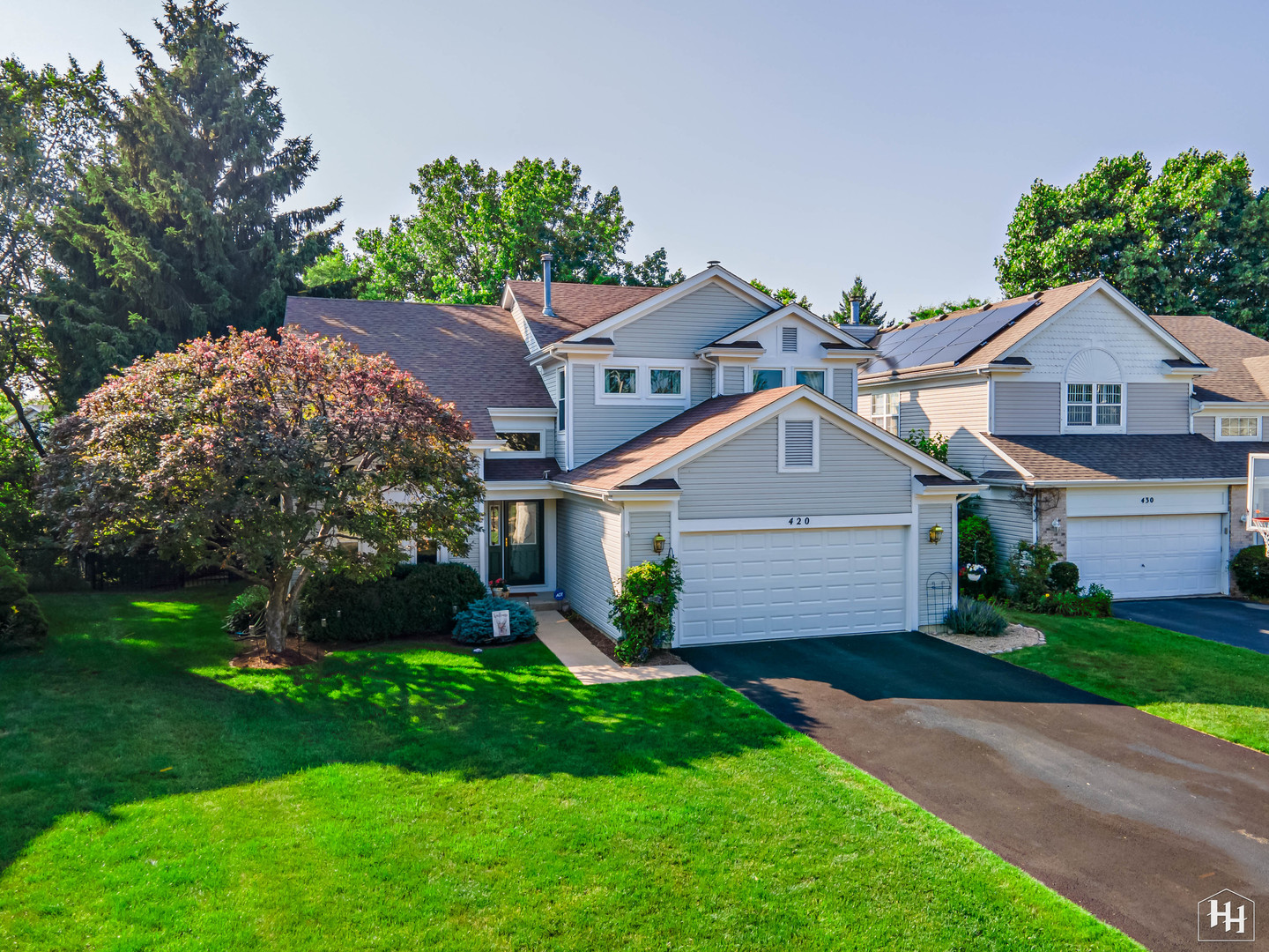 a front view of a house with a garden and plants