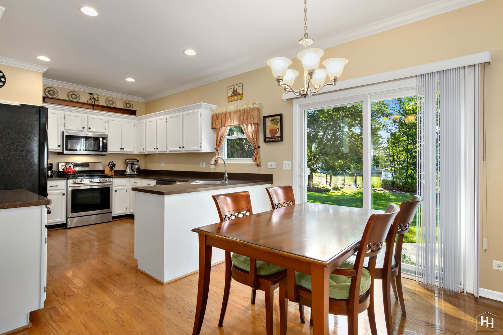 420 5th Street Wheeling, IL 60090 - Photo 3 of 34 a kitchen with stainless steel appliances granite countertop a stove a refrigerator a kitchen island a stove a dining table and chairs with wooden floor