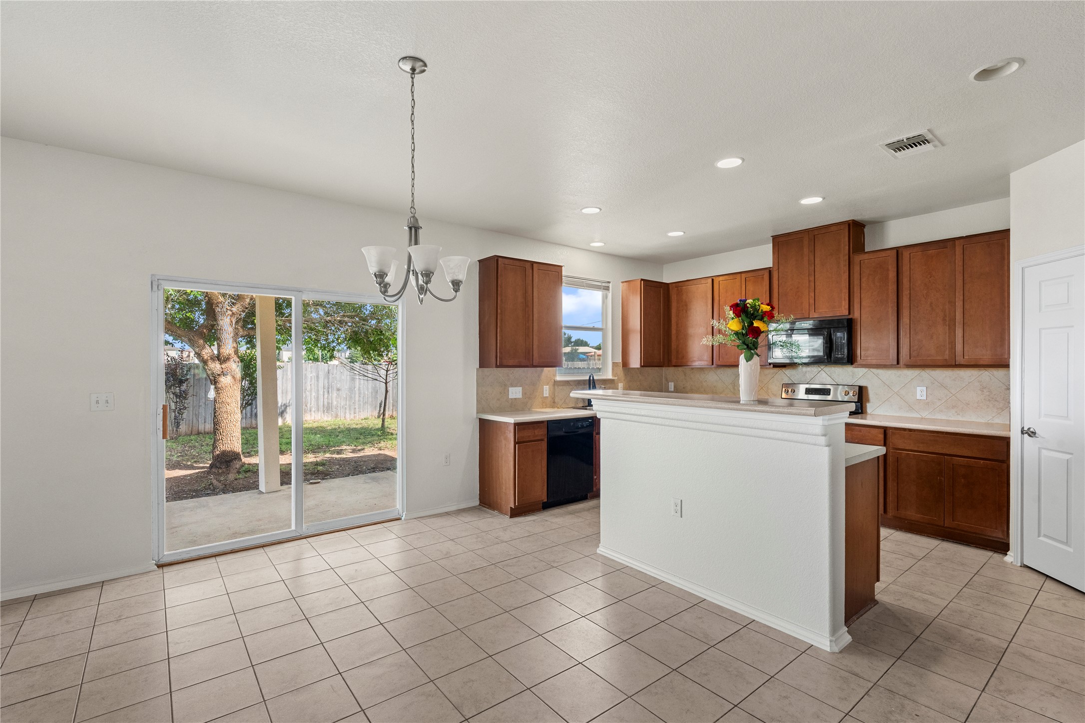 8613 Capitol View Drive Austin, TX 78747 - Photo 20 of 33 A well-lit kitchen and dining area provides direct access to the private backyard through sliding glass doors.