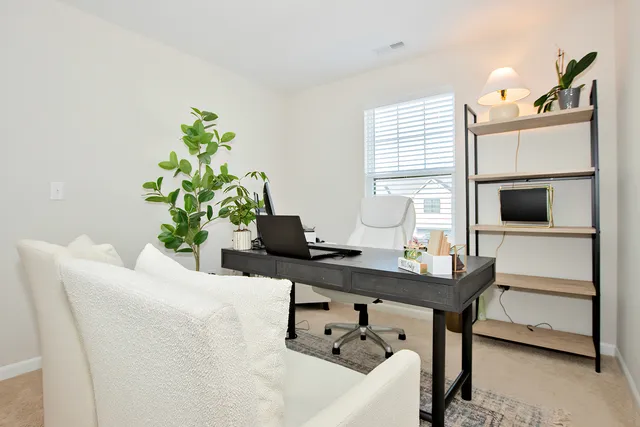 a dining room with furniture and a potted plant
