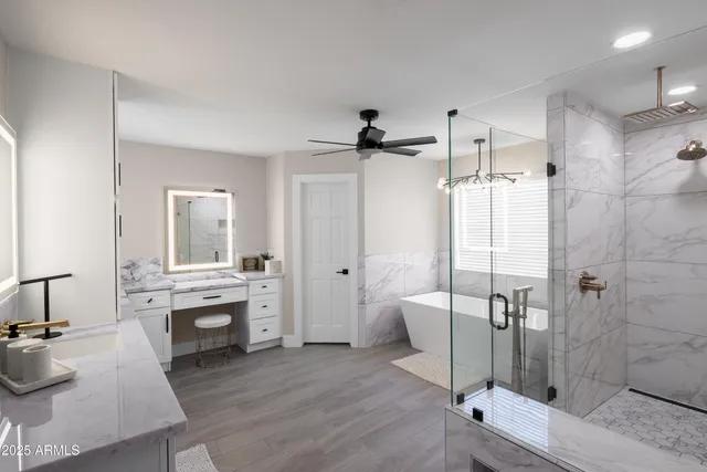 a spacious bathroom with white cabinets sink and mirror