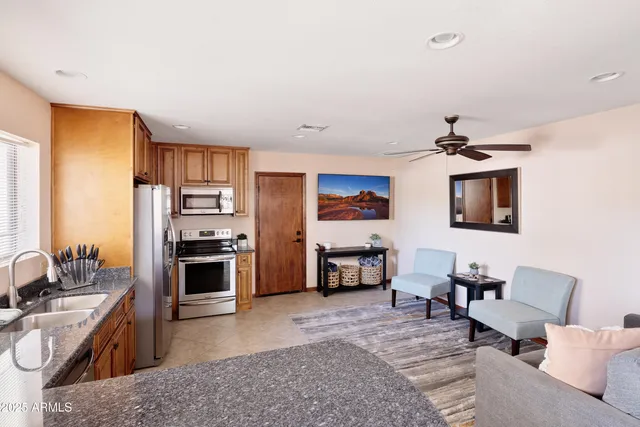 a kitchen with stainless steel appliances granite countertop a refrigerator a sink a stove and island