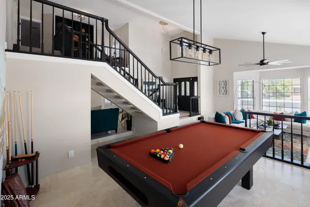 a living room with furniture pool table and windows
