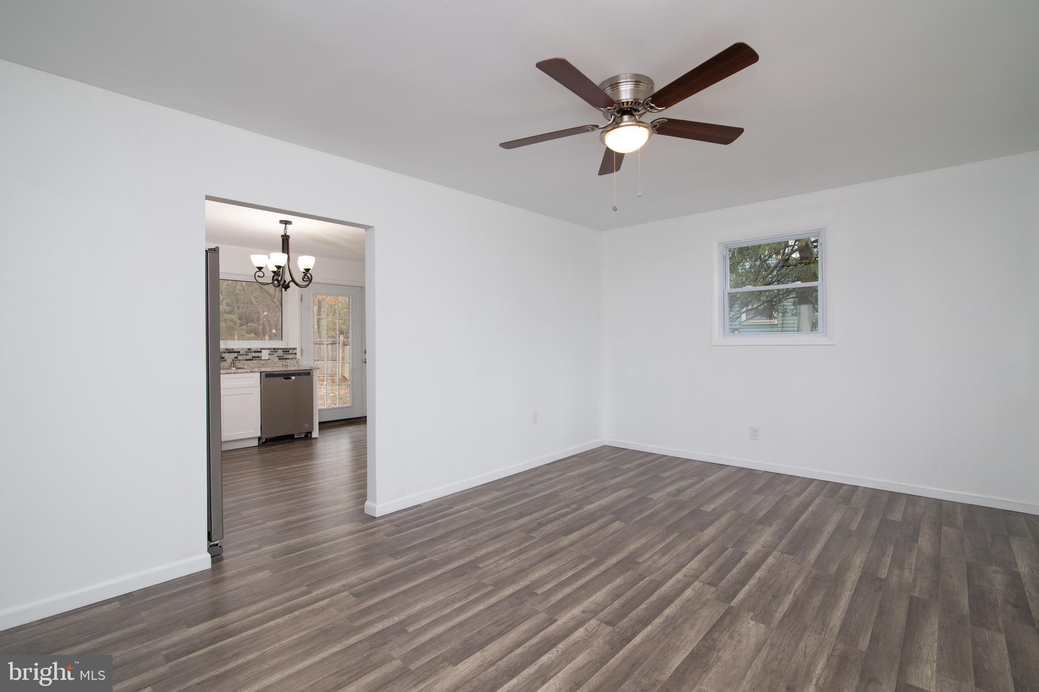 112 Country Club Road Pine Hill, NJ 08021 - Photo 3 of 22 an empty room with wooden floor and a ceiling fan