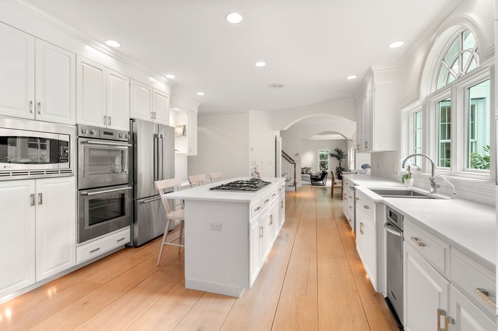 82 Sargent Road Brookline, MA 02445 - Photo 19 of 41 a kitchen with stainless steel appliances granite countertop a stove top oven a sink dishwasher a refrigerator and white cabinets with wooden floor