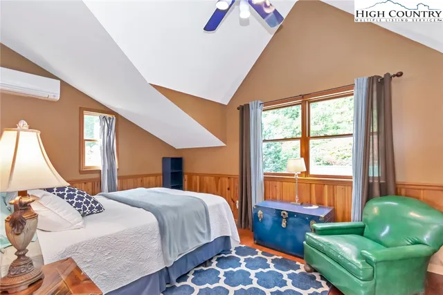 a bedroom with a bed and a couch next to a window