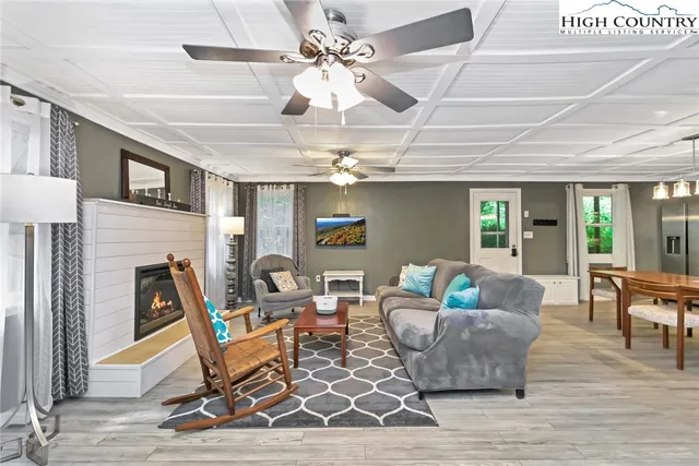 a living room with furniture a fireplace and a chandelier