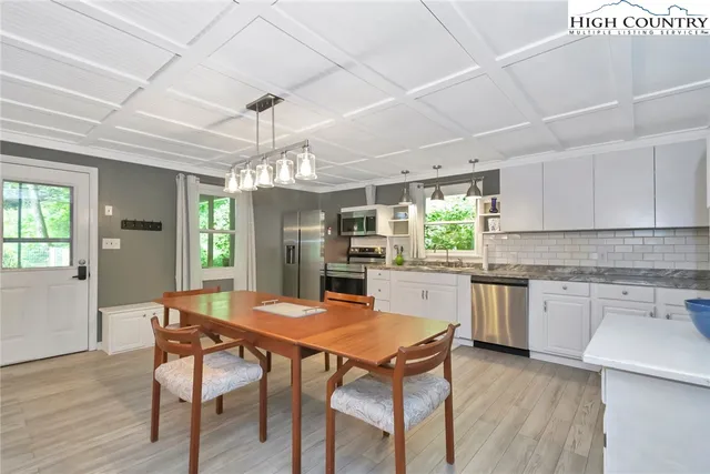 a kitchen with a table chairs a sink dishwasher window and cabinets
