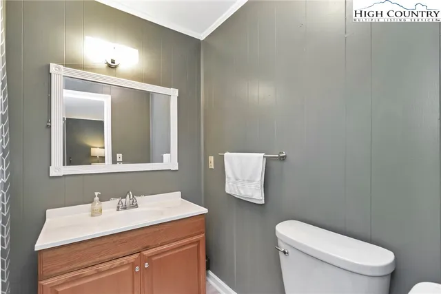 a bathroom with a toilet a sink and mirror