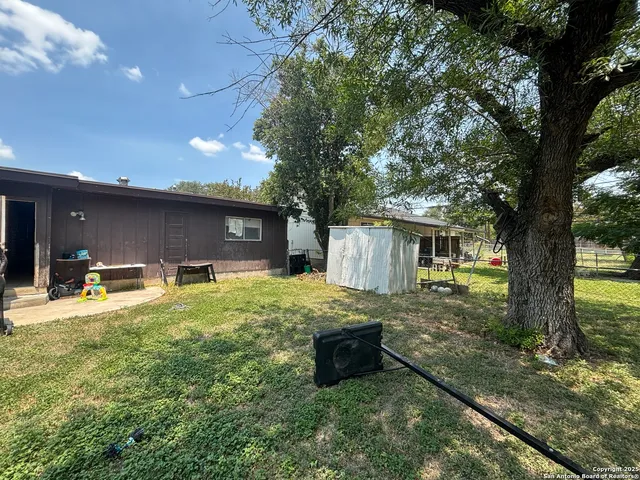 a backyard of a house with table and chairs
