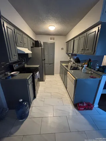 a kitchen with refrigerator and cabinets
