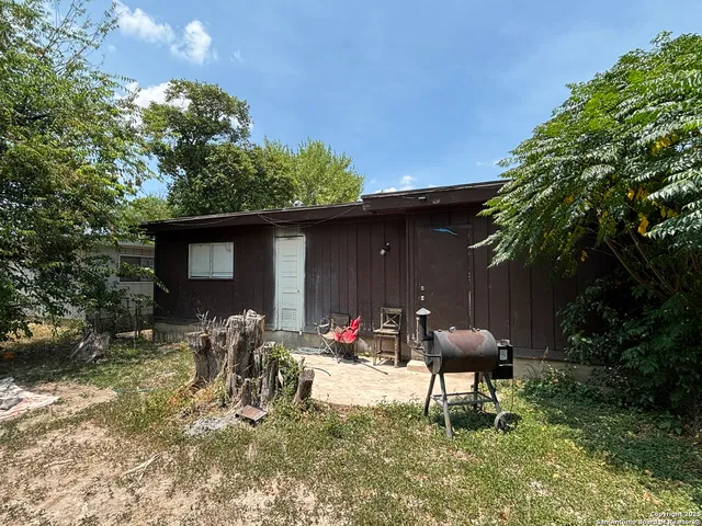 a backyard of a house with table and chairs
