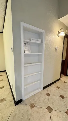 a view of a hallway with entryway and chandelier