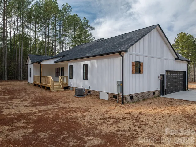 a view of a house with backyard and a tree
