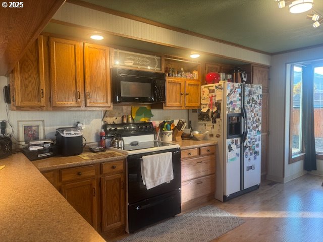 1911 15th Street Baker City, OR 97814 - Photo 13 of 33 a kitchen with stainless steel appliances granite countertop a stove refrigerator sink and microwave