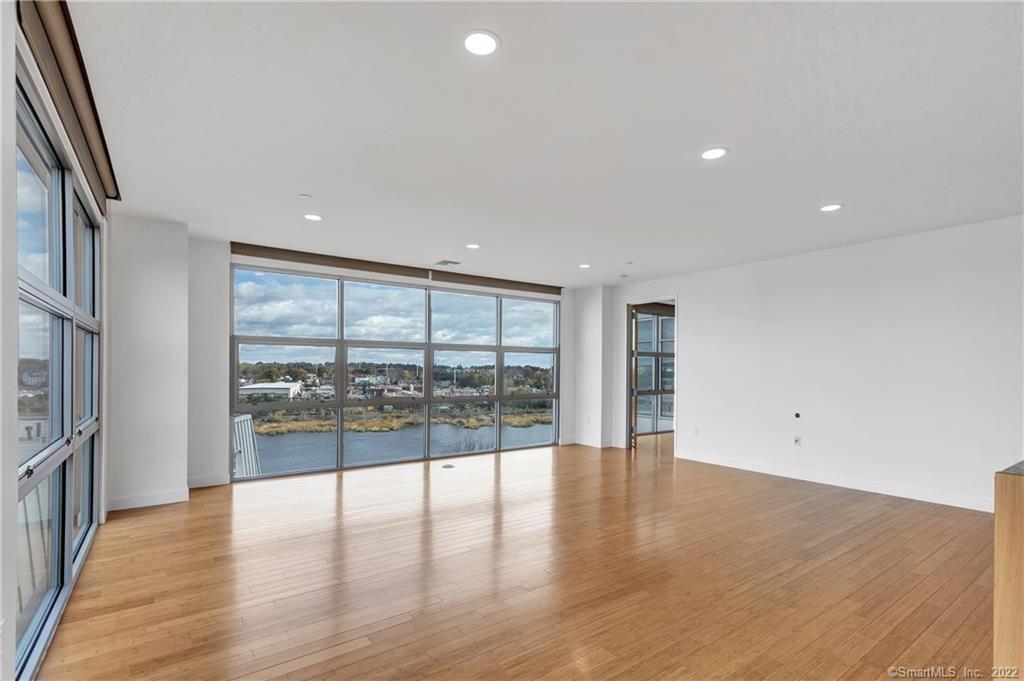 33 North Water Street, Unit 607 Norwalk, CT 06854 - Photo 2 of 40 an empty room with wooden floor and windows