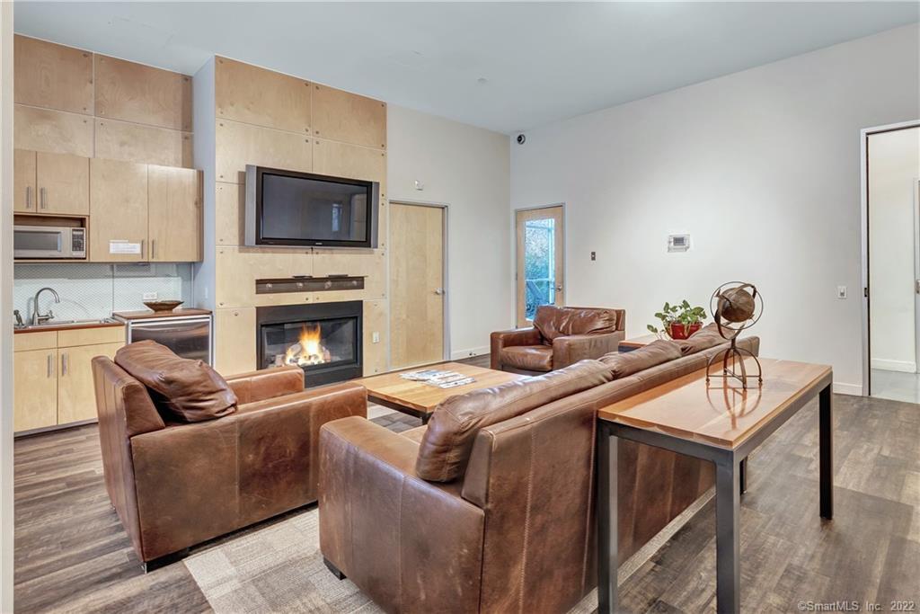 33 North Water Street, Unit 607 Norwalk, CT 06854 - Photo 33 of 40 a living room with furniture a flat screen tv and a fireplace