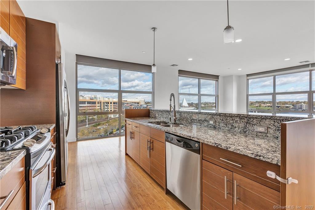 33 North Water Street, Unit 607 Norwalk, CT 06854 - Photo 5 of 40 a kitchen with stainless steel appliances granite countertop a stove a sink and a wooden floors