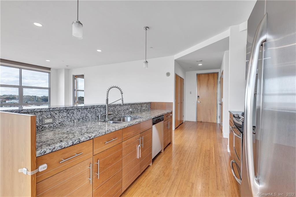 33 North Water Street, Unit 607 Norwalk, CT 06854 - Photo 6 of 40 a kitchen with stainless steel appliances granite countertop a sink stove and refrigerator