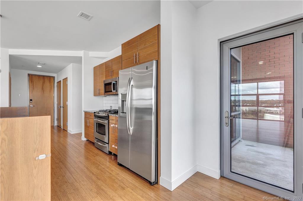 33 North Water Street, Unit 607 Norwalk, CT 06854 - Photo 8 of 40 a kitchen with stainless steel appliances a refrigerator and a stove top oven