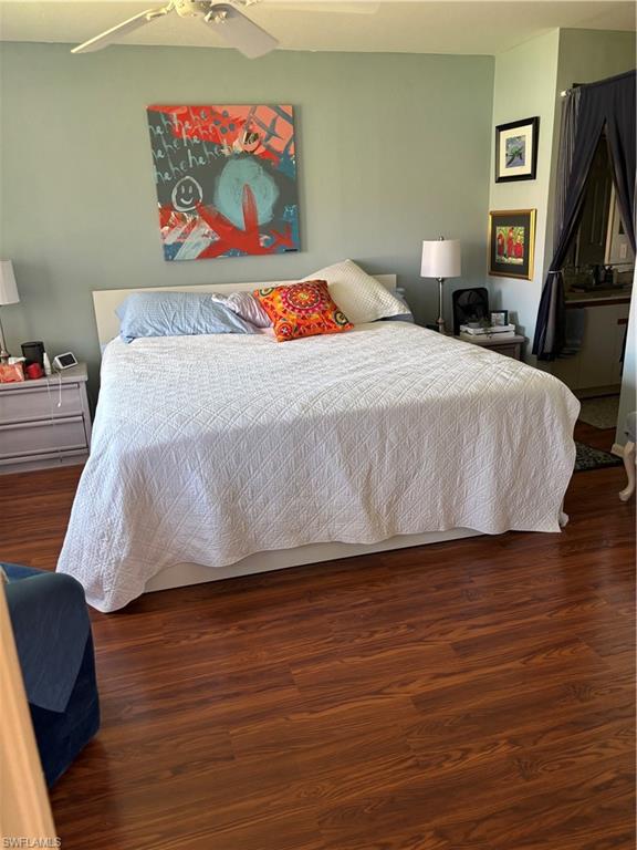 4983 Pepper Circle, Unit H201 Naples, FL 34113 - Photo 14 of 17 a bedroom with a bed and wooden floor