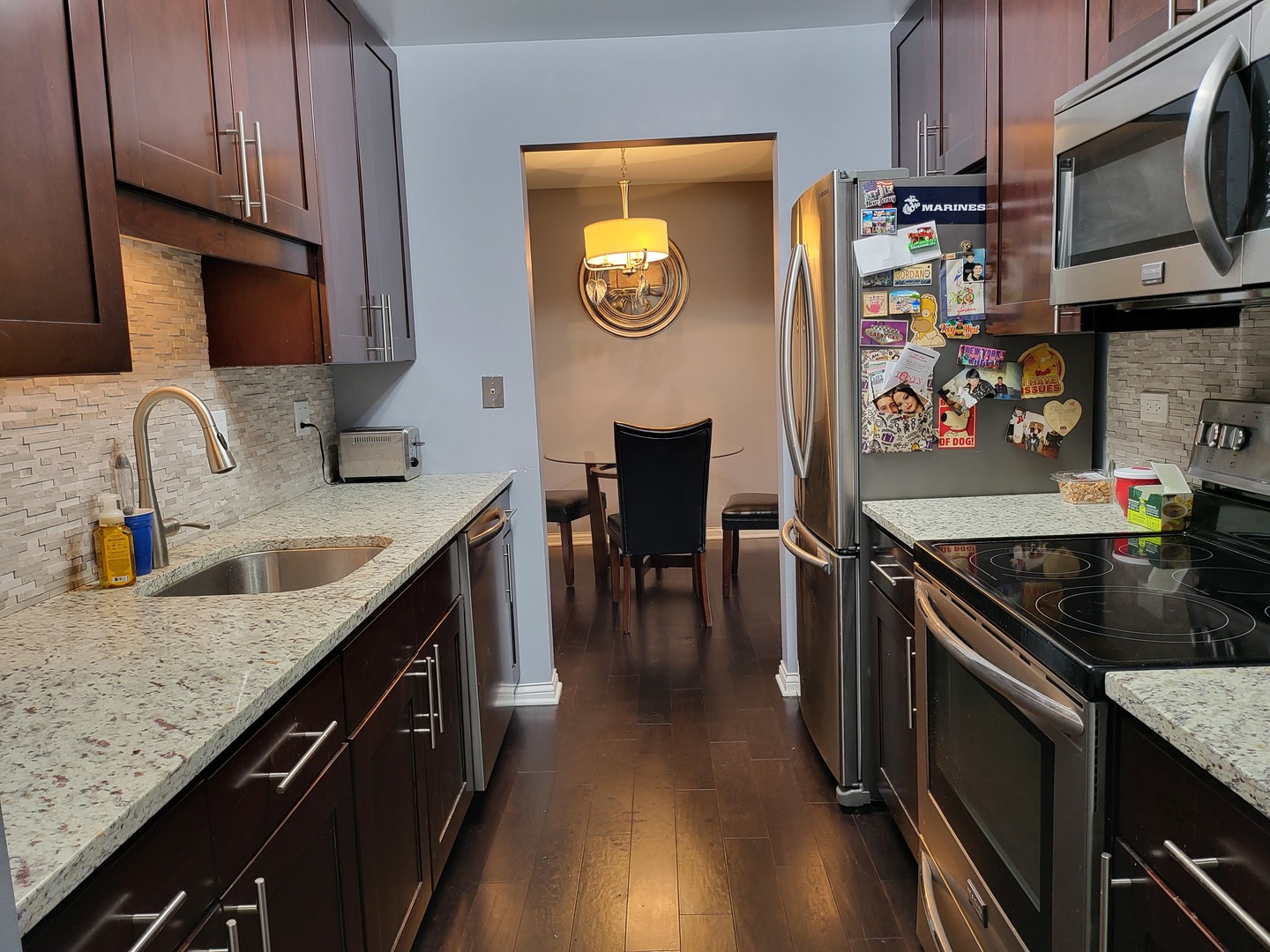 201 Thames Parkway, Unit 2K Park Ridge, IL 60068 - Photo 2 of 9 a kitchen with granite countertop stainless steel appliances and wooden cabinets