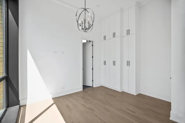 an empty room with wooden floor and door